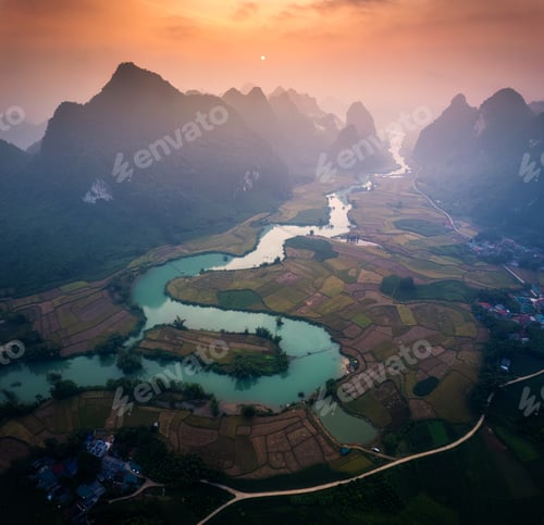 Preview: Sunrise over mountain range with foggy on rural village and river flows through in Phong Nam Valley