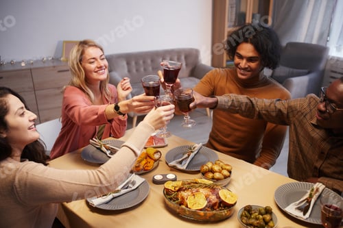 Preview: Friends Toasting With Wine at Dinner Table
