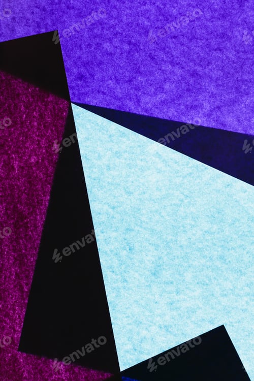 Preview: Overlapping pieces of multicolored construction paper on illuminated backdrop.