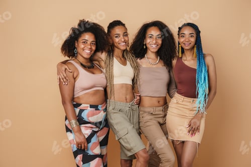 Preview: Young black four women hugging and laughing at camera