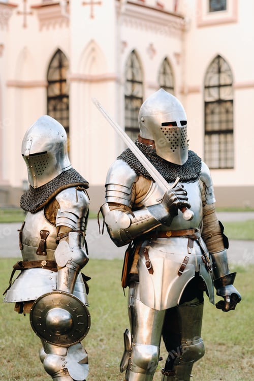 Preview: Two knights in armor on the background of a medieval castle.A medieval concept.Metallic texture