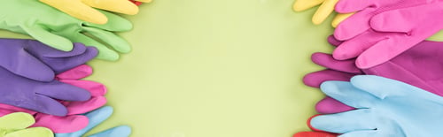 Preview: panoramic shot of bright rubber gloves on green background with copy space