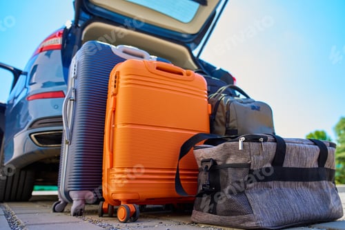 Preview: Luggage standing near car with open trunk ready for travel or moving
