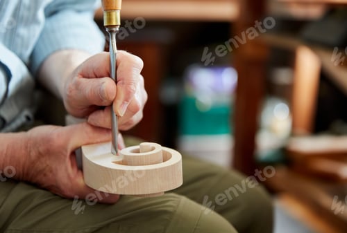 Preview: A violin maker using hand tools to smooth and finish a new wooden vioin headstock, curled scroll of