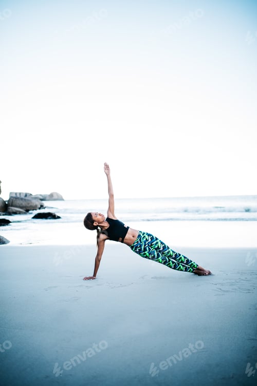 Preview: Young african women doing Yoga exercise on the Beach in the early morning