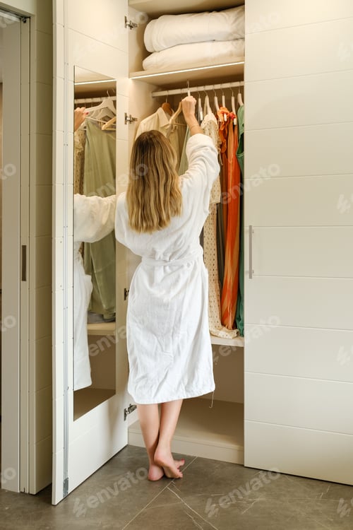 Preview: Woman choosing clothes in wardrobe