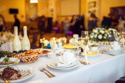 Preview: Wedding table in the restaurant decorated with white candles and flowers.