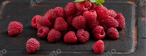 Preview: Ripe red raspberries on a brown wooden board