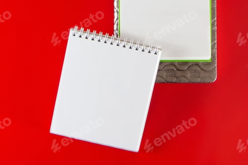 Preview: Minimalistic layout for design. Office supplies - notebooks and pens on a red background.