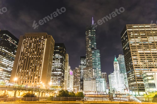 Preview: Chicago riverwalk at night showing illuminated buildings and cloudy sky