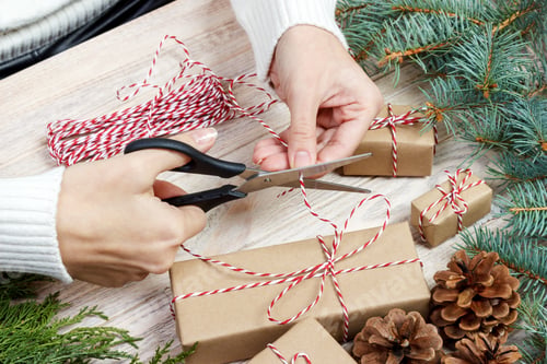 Preview: Christmas gift wrapping background. Female hands packaging christmas present
