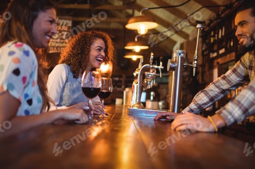 Preview: Young women interacting with bartender at counter