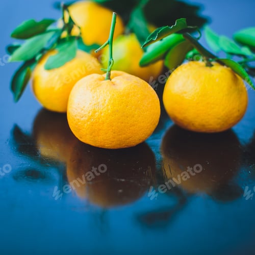 Preview: Tangerines with leaves on a wooden table.