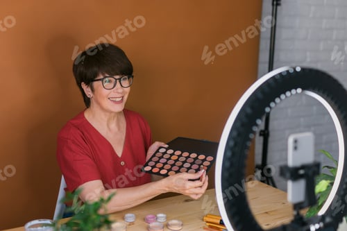 Preview: Beauty and cosmetics e-commerce and blogging concept - professional mature female make up artist