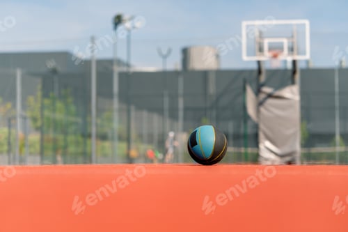 Preview: Close-up of basketball that lies on the floor of a basketball court in a park
