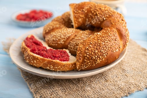 Preview: Homemade sweet bun with raspberry jam and cup of coffee on a blue wooden background and linen textil