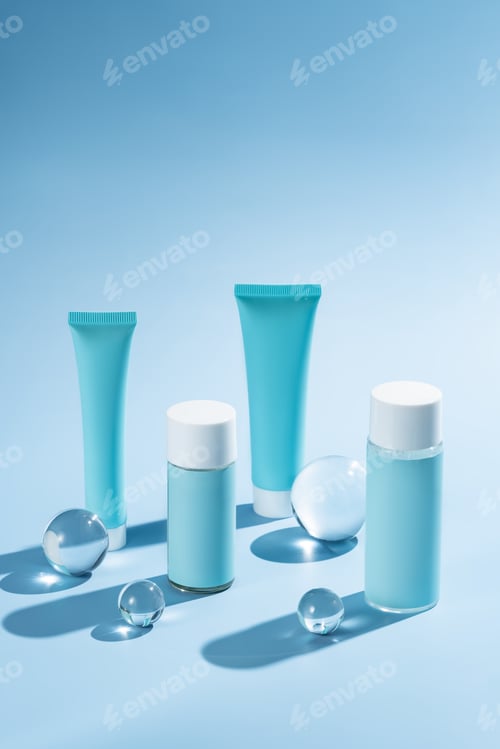 Preview: Mockup of blue plastic bottles and tubes with face serum or cream, or toner on blue background