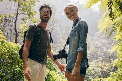 Preview: Hiker couple standing together during rain in the forest