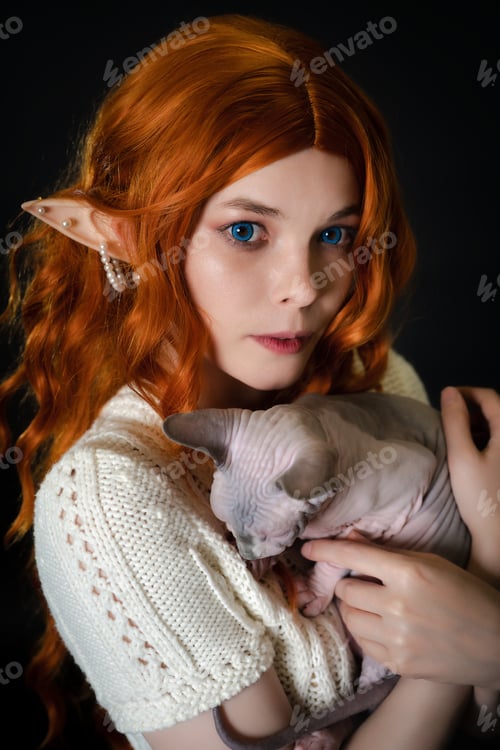 Preview: Portrait of cosplay elf young woman in white knitted dress holding sleepy Sphinx pussycat in hands