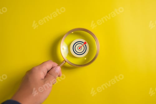 Preview: People holding magnifying glass with business goal icon