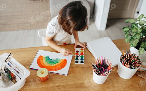 Preview: Kids painting watercolor rainbows at table at home
