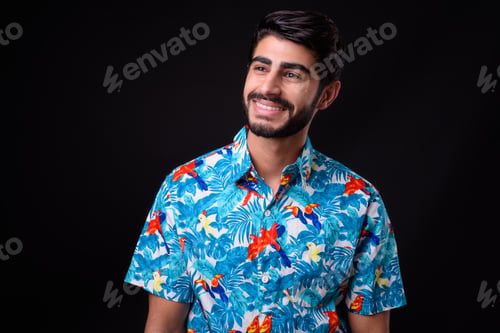 Preview: Young handsome bearded Persian tourist man ready for vacation against black background