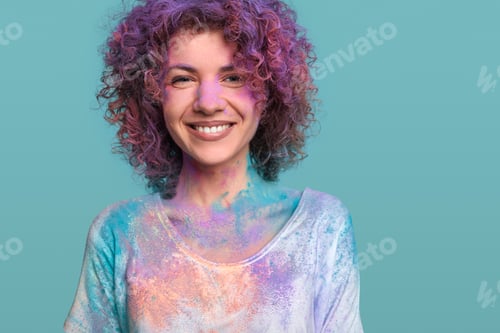 Preview: Smiling woman in Holi colors in studio