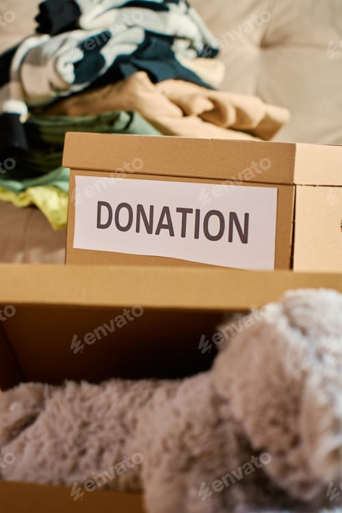 Preview: Clothes prepared for donation in cardboard box