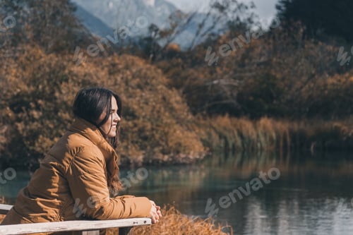 Preview: Young female admiring beautiful autumn nature at Zelenci nature reserve in Slovenia
