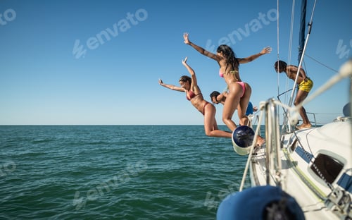 Preview: Multiracial friends jumping out of boat in the sea while having fun in their summer vacation