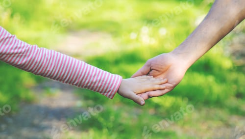 Preview: A child with his father goes by the hand. Selective focus