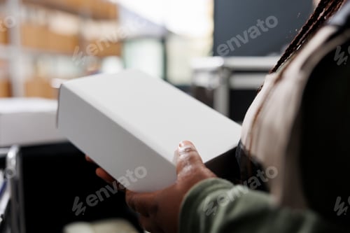 Preview: Storage room worker holding white cardboard boxes,