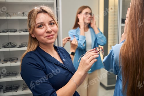 Preview: Doctor optician showing glasses to a customer