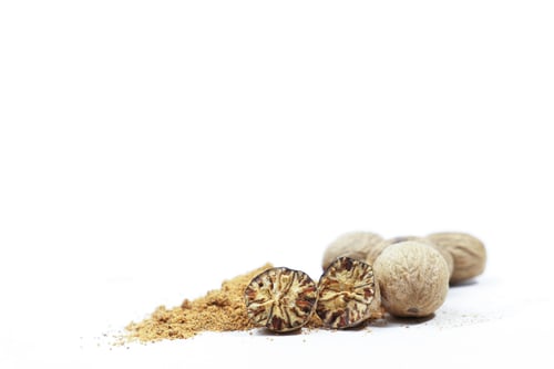 Preview: whole nutmeg, halved and ground, on a wooden spoon