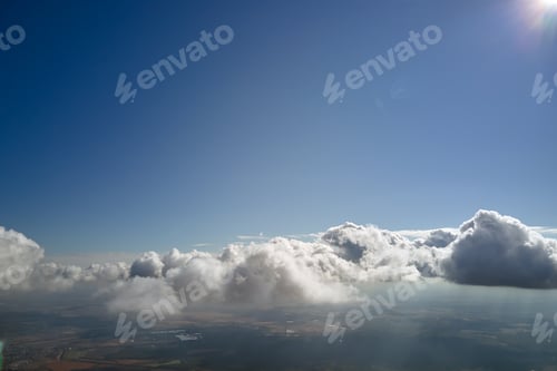 Preview: Aerial view from airplane window at high altitude of earth covered with white puffy cumulus clouds