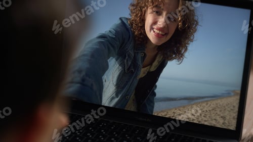 Preview: Happy girl videocalling laptop closeup. Unknown kid waving sister on screen