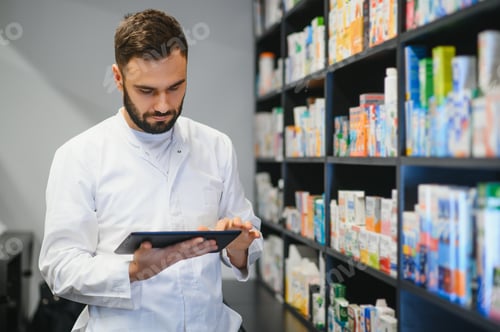 Preview: Pharmacist using digital tablet checking inventory in drugstore