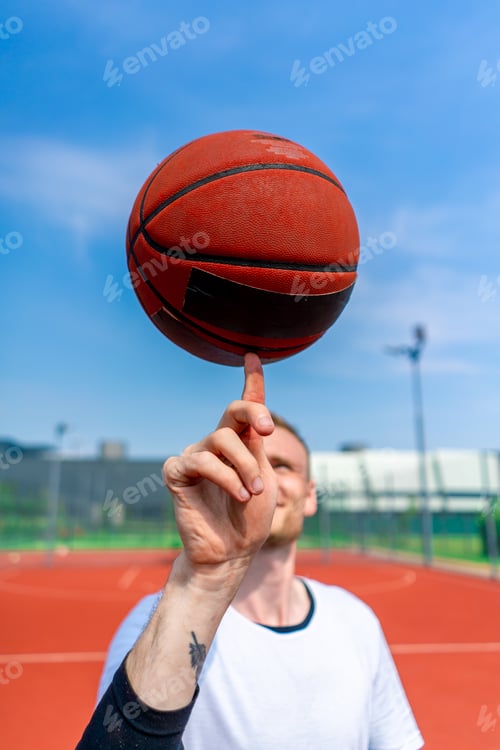 Preview: Close-up of guy basketball player spinning a basketball on his finger showing his freestyle skills