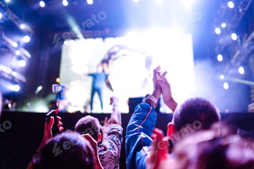 Preview: Сrowd with raised hands at music festival. Fans enjoying rock concert with light show clapping hands