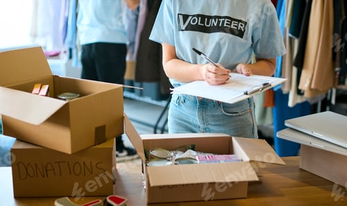 Preview: Close Up Of Female Charity Worker Checking Food Donations At Foodbank Or Thrift Store