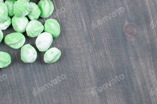 Preview: Pile of green candies on wooden surface