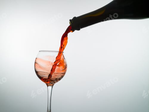 Preview: Red wine pouring into a wine glass, white background