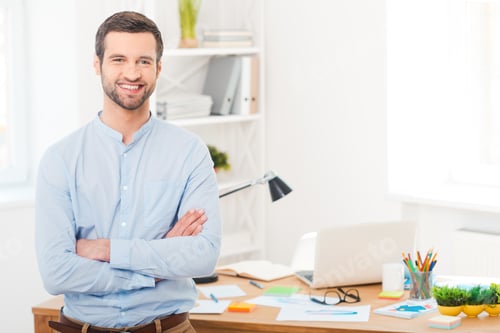 Smiling Man with Crossed Arms in Office Setting