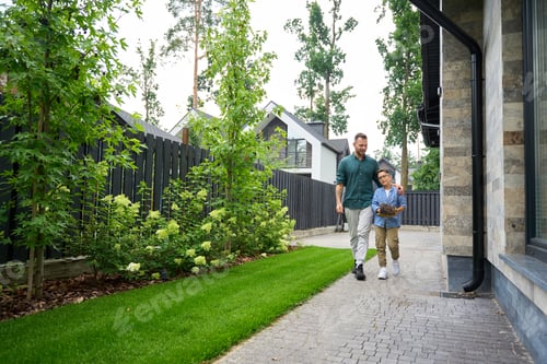 Preview: Man and his son walk through yard of country house