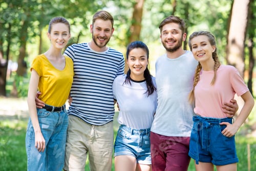 Preview: smiling friends hugging and posing together in park