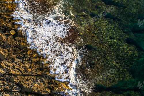 Preview: Ocean coast, blue waters and waves on the rocky beach