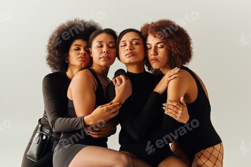 Preview: young sexy african american female friends in alluring bodysuits posing together, fashion concept