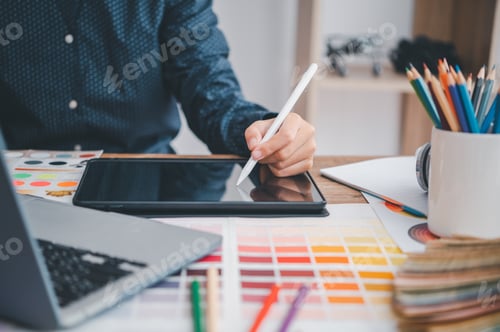 Preview: Graphic designer architects who work with laptops and color comparison tables for design work.