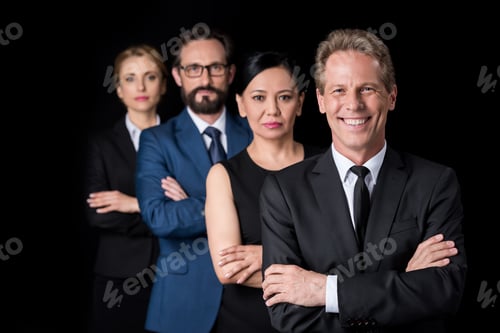 Preview: confident multiethnic group of businesspeople standing with crossed arms and looking at camera