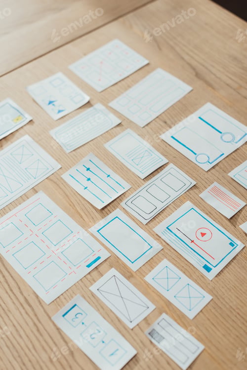 Preview: High angle view of layouts of user experience design on wooden table